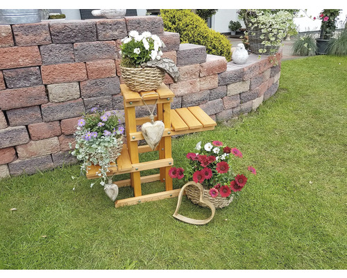 Dekorative Gartenszene mit Blumen, Blumenständer und Steinmauer