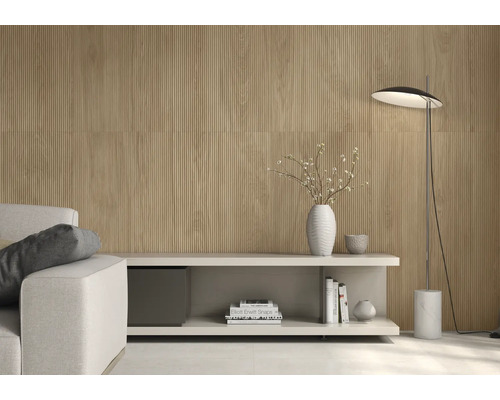 Heller Wohnraum mit geriffelten Wandpaneelen, Sideboard, Stehlampe und Sofa.