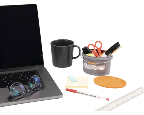 Szene mit einem Laptop, einer Tasse, einem Eimer mit Büroartikeln, Haftnotizen, einem Stift und einem Lineal.