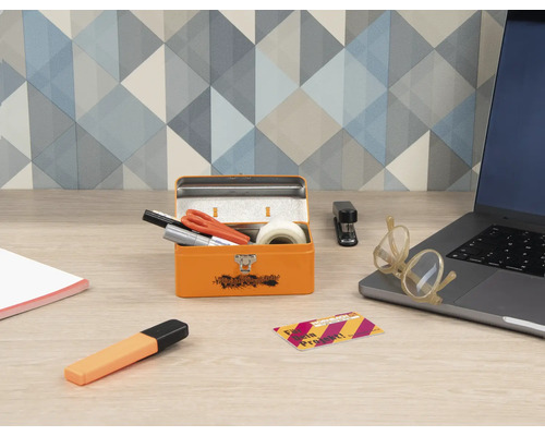 Szene mit geöffnetem, orangefarbenem Werkzeugkasten, Büroartikeln und Laptop auf einem Schreibtisch