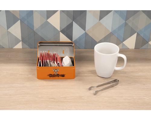 Teebox aus Metall mit Teebeuteln, Tasse und Zuckerzange