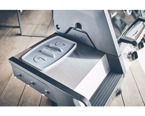 Detailansicht eines Gasgrills mit Ablagefläche und Besteckhalter.