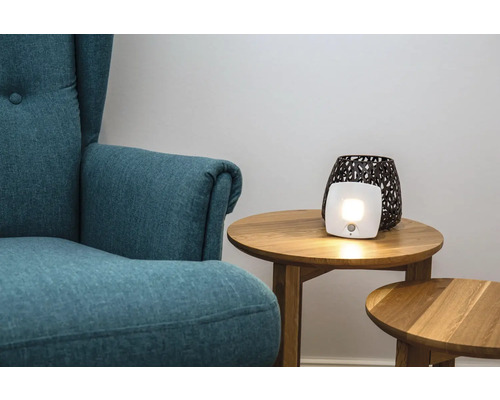 Wohnzimmer mit Sessel und Tageslichtlampe auf einem Beistelltisch