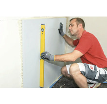 Mann richt Bauplatte mit Wasserwaage aus