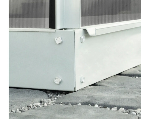 Detailansicht des Fundaments eines Gewächshauses mit Schrauben auf Pflastersteinen