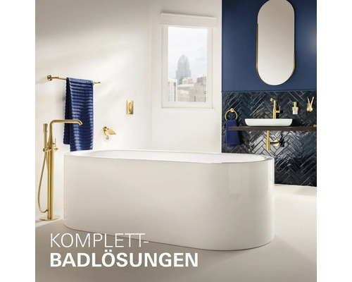 Badezimmer mit freistehender Badewanne, Waschtisch, Spiegel und goldenen Armaturen