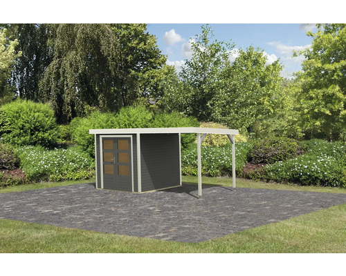 Gartenhaus mit Überdachung auf gepflasterter Fläche vor Büschen und Bäumen.