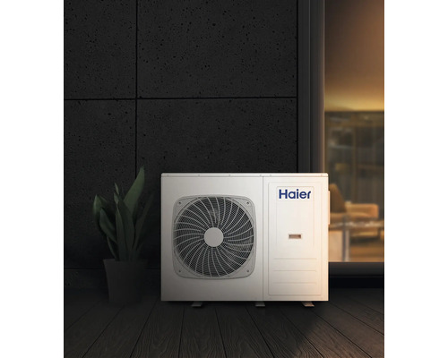 Haier Klimaanlage Außeneinheit neben einer Zimmerpflanze