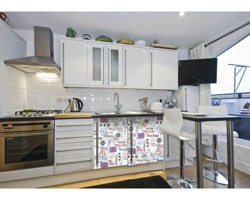 Helle Küche mit weißen Schränken, Geräten aus Edelstahl und einem Esstisch mit Barhockern.