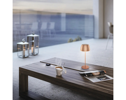 Szene mit Tischleuchte, Tasse Kaffee und Zeitung auf einem Tisch