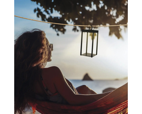 Dekorative Hängeleuchte aus Metall über einer Frau in einer Hängematte am Strand