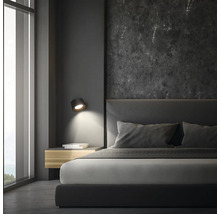 Schlafzimmer mit Doppelbett, Nachttisch, Wandleuchte und großem Fenster