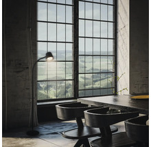Helles Interieur mit Esstisch, Stühlen, Stehlampe und großem Fenster mit Blick auf die Landschaft