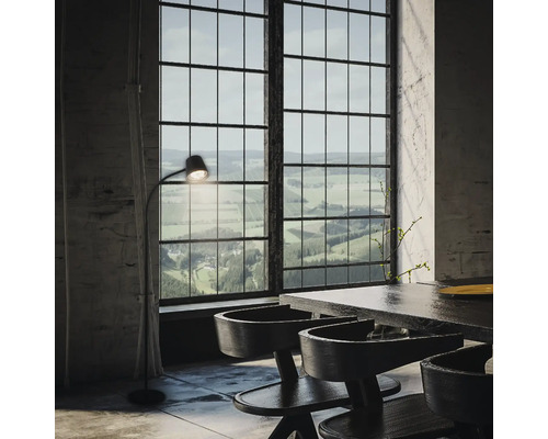 Helles Interieur mit Esstisch, Stühlen, Stehlampe und großem Fenster mit Blick auf die Landschaft