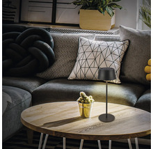 Dekorative Tischleuchte auf einem Holztisch in einem Wohnzimmer.