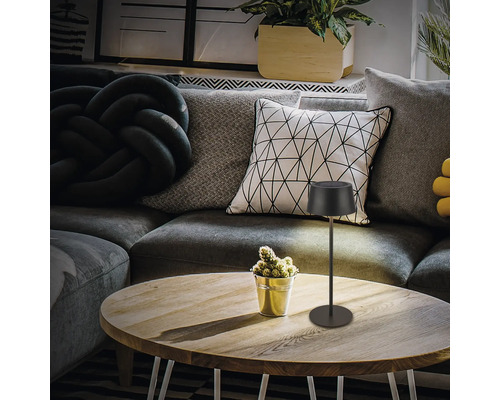 Dekorative Tischleuchte auf einem Holztisch in einem Wohnzimmer.