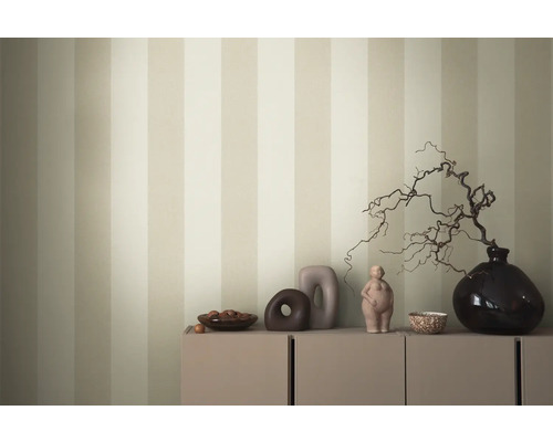 Dekoratives Arrangement auf einem Schrank vor einer gestreiften Tapete.