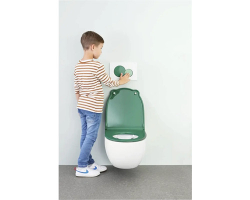 Kind an einer Toilette mit grüner Klobrille und Betätigungsplatte
