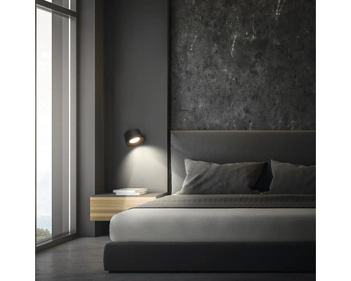 Schlafzimmer mit Bett, Nachttisch und Wandleuchte