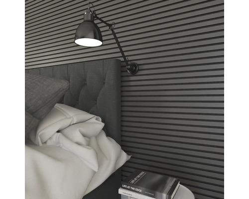 Schlafzimmer mit Bett, Nachttisch, Wandpaneelen und Wandleuchte