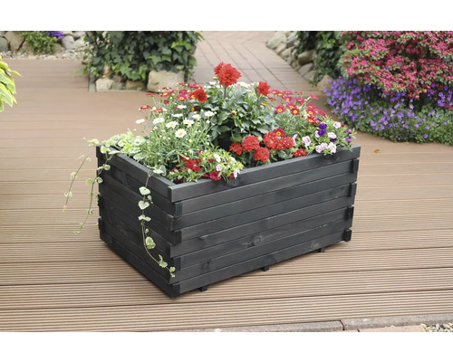 Holzblumenkasten mit bunten Blumen auf einer Terrasse