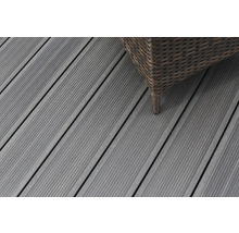 Nahaufnahme von grauen Terrassendielen aus Holz mit einem Möbelstück