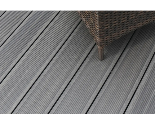 Nahaufnahme von grauen Terrassendielen aus Holz mit einem Möbelstück