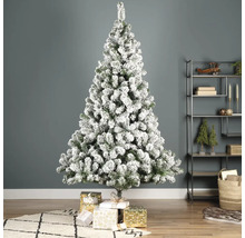Geschmückter, beschneiter Weihnachtsbaum mit Geschenken im Wohnzimmer.