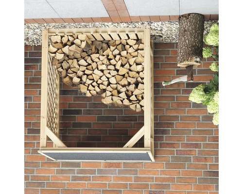 Holzlager mit Holz und Axt an einer Mauer