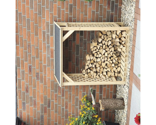 Holzlager aus Holz mit Holzscheiten vor einer Ziegelwand