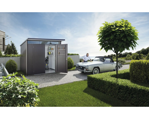 Metallgerätehaus mit geöffneten Türen, Regalen und Hochdruckreiniger neben einem Mann, der ein Auto putzt