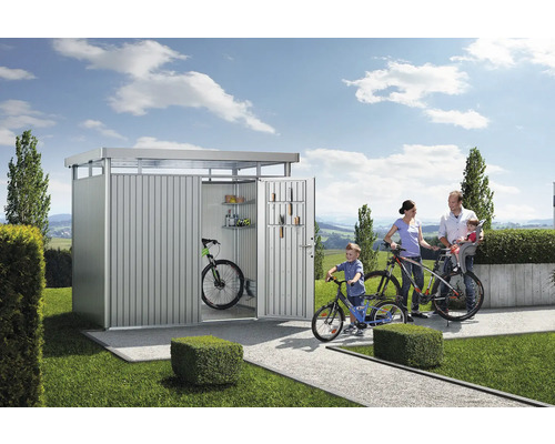 Familie mit Fahrrädern vor einem Gerätehaus aus Metall im Garten.