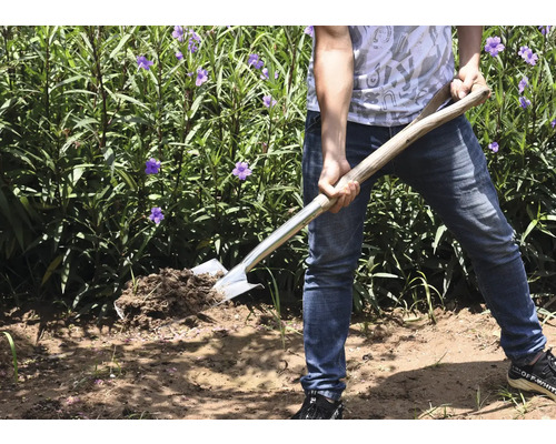 Person mit Spaten im Garten beim Umgraben von Erde