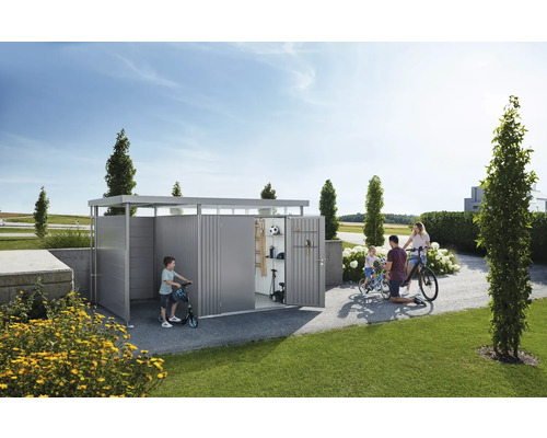 Familie vor einer Geräteaufbewahrung mit Fahrrädern und Spielsachen im Garten