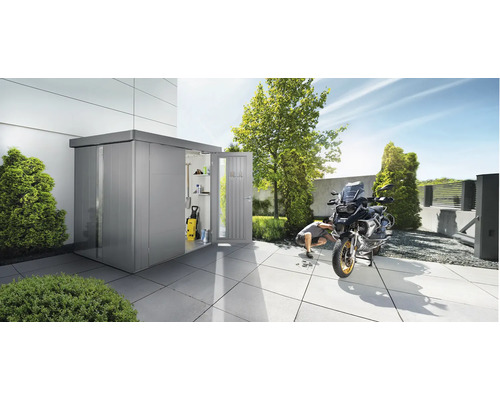 Metall Gerätehaus mit geöffneter Tür, Mann repariert Motorrad im Garten.