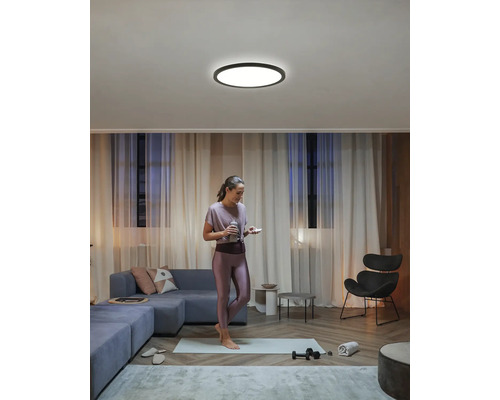 Helle Wohnung mit Deckenleuchte und Frau beim Sport