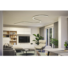 Wohnzimmer mit moderner Deckenleuchte, Sofa, Sessel und TV-Wand.