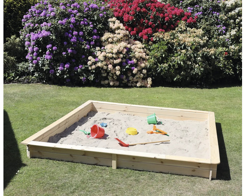 Sandkasten aus Holz mit Spielzeug im Garten
