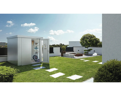 Garten mit Metall Gerätehaus, geöffneter Tür und Gartengeräten