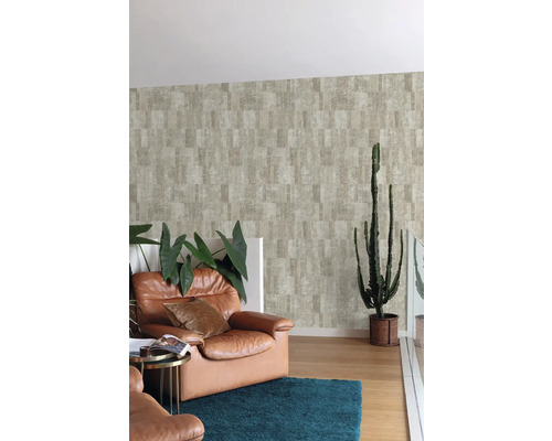 Wohnzimmer mit braunem Ledersessel, blauem Teppich und gemusterter Tapete