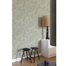 Raumansicht mit floral gemusterter Tapete, Hockern und Lampe