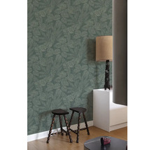 Wohnraum mit gemusterter Tapete, zwei Hockern und Lampe