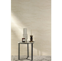 Dekoratives Stillleben mit Kerze, Vase und Duftkerze auf einem Beistelltisch vor einer gemusterten Wand