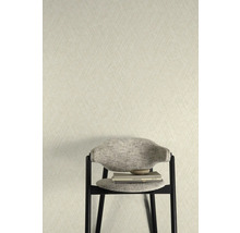 Nahaufnahme einer Wand mit einer strukturierten Tapete und einem Stuhl mit Büchern