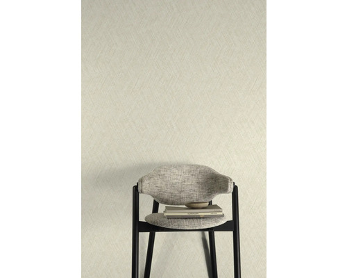 Nahaufnahme einer Wand mit einer strukturierten Tapete und einem Stuhl mit Büchern
