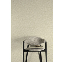 Tapete mit Fischgrätmuster hinter einem Stuhl mit Büchern