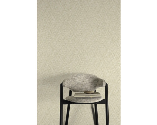 Tapete mit Fischgrätmuster hinter einem Stuhl mit Büchern