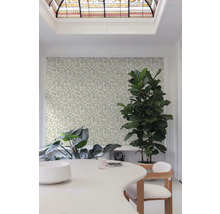 Heller Raum mit floral gemusterter Tapete, Tisch und Zimmerpflanzen.