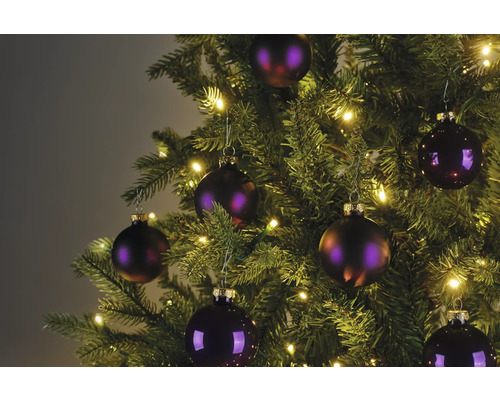 Nahaufnahme eines Weihnachtsbaums mit Kugeln und Lichterkette.