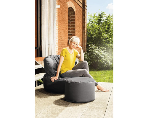 Frau entspannt auf einem grauen Sitzsack mit Hocker im Freien